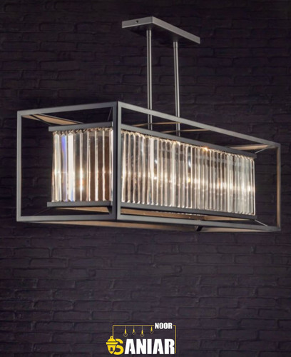 لوستر آویز خطی مستطیلی با فریم فلزی مشکی و کریستالهای شفاف روشن در پس زمینه دیوار آجری تیره.