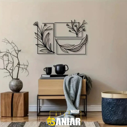 ست سه تایی تابلو دیواری مشکی طرح شاخههای بهاری نصب شده روی دیوار کرم بالای یک نیمکت چوبی مدرن».