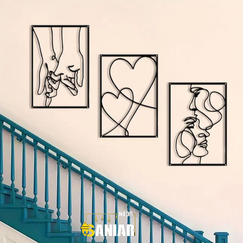 ست سه تایی تابلو دکوراتیو مشکی لاینآرت با طرحهای دست، قلب و چهره زوج که به صورت پلکانی روی دیوار کرم بالای پلههای آبی نصب شده است».