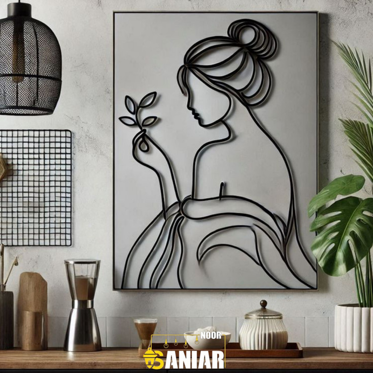 تابلو دکوراتیو لاینآرت مشکی طرح نیمرخ بانوی با موهای جمع شده و شکوفهای در دست روی دیوار خاکستری بالای پیشخوان آشپزخانه».