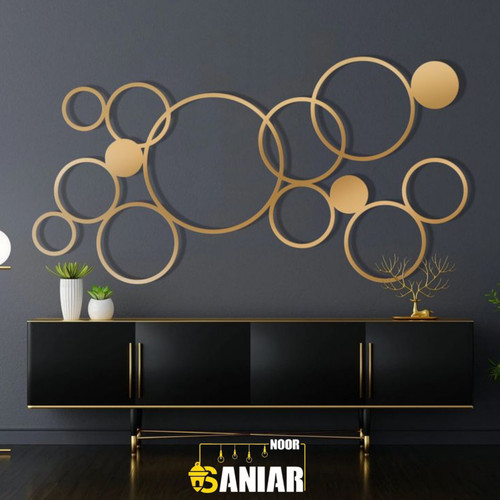 پنل دکوراتیو طلایی بزرگ با طرح دایرههای درهمتنیده هندسی نصب شده روی دیوار تیره بالای یک کنسول مشکی لوکس».