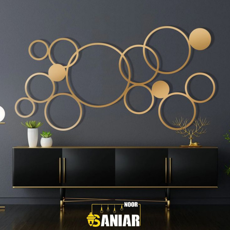 پنل دکوراتیو طلایی بزرگ با طرح دایرههای درهمتنیده هندسی نصب شده روی دیوار تیره بالای یک کنسول مشکی لوکس».