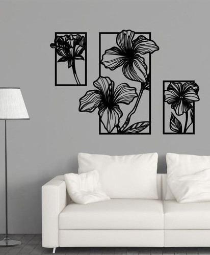 ست سه عددی تابلو دکوراتیو مشکی با طرح گلهای خطی انتزاعی که به صورت پلهای روی دیوار طوسی بالای کاناپه سفید نصب شدهاند».