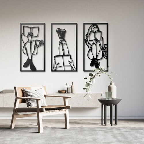 ست سه تایی تابلو دکوراتیو مشکی با طرحهای لاینآرت دختر در حال مطالعه و قهوه خوردن نصب شده روی دیوار سفید بالای مبل تکنفره».