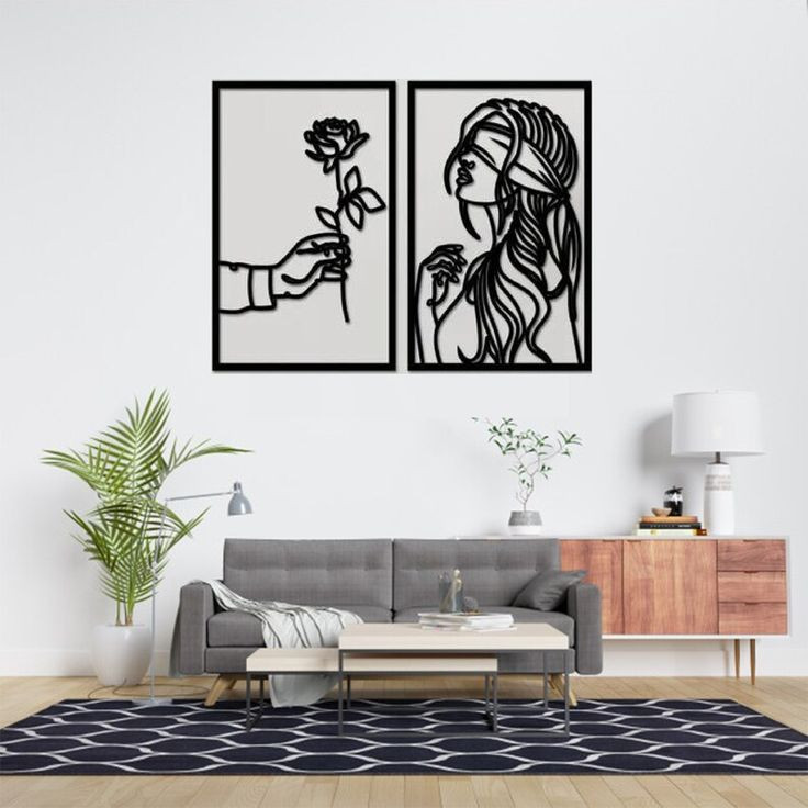 ست دو عددی تابلو مشکی لاینآرت با طرح دست نگهدارنده گل رز و نیمرخ بانو نصب شده روی دیوار سفید بالای مبلمان خاکستری مدرن».