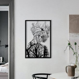 تابلو فلزی مستطیلی مشکی با طرح نیمرخ انسان که با شاخههای درخت و پرندگان ترکیب شده است، نصب شده روی دیوار سفید اتاق».