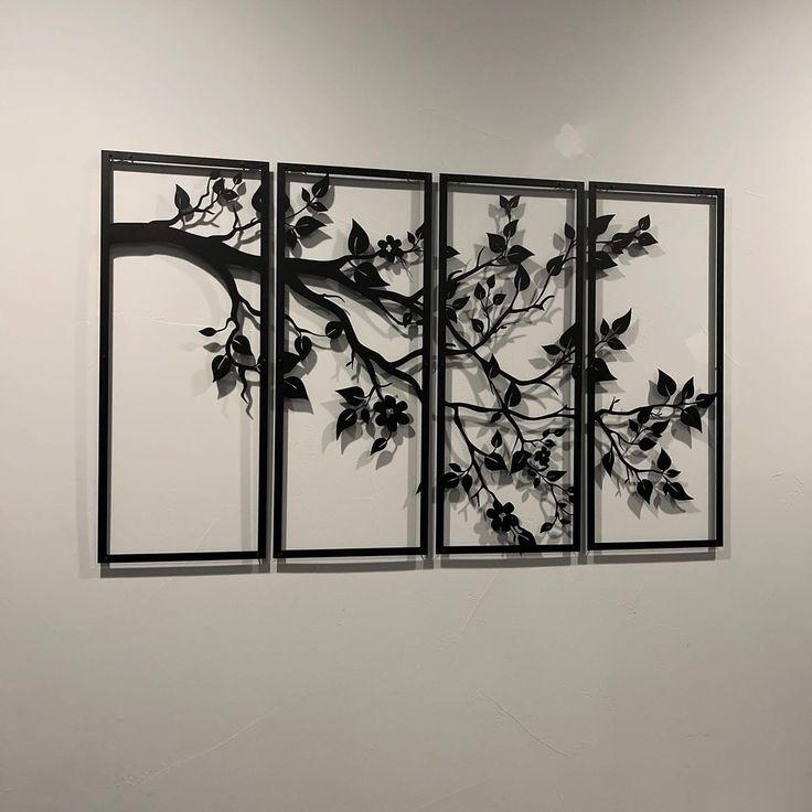 ست چهار عددی قاب فلزی مشکی با طرح یک شاخه بلند پربرگ که به صورت افقی در امتداد هم روی دیوار سفید نصب شدهاند».