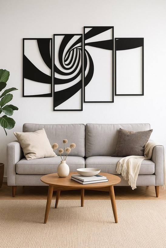 ست چهار تایی قاب فلزی مشکی با طرح مارپیچ هندسی که به صورت متقارن و پلکانی روی دیوار سفید بالای کاناپه طوسی نصب شده است».