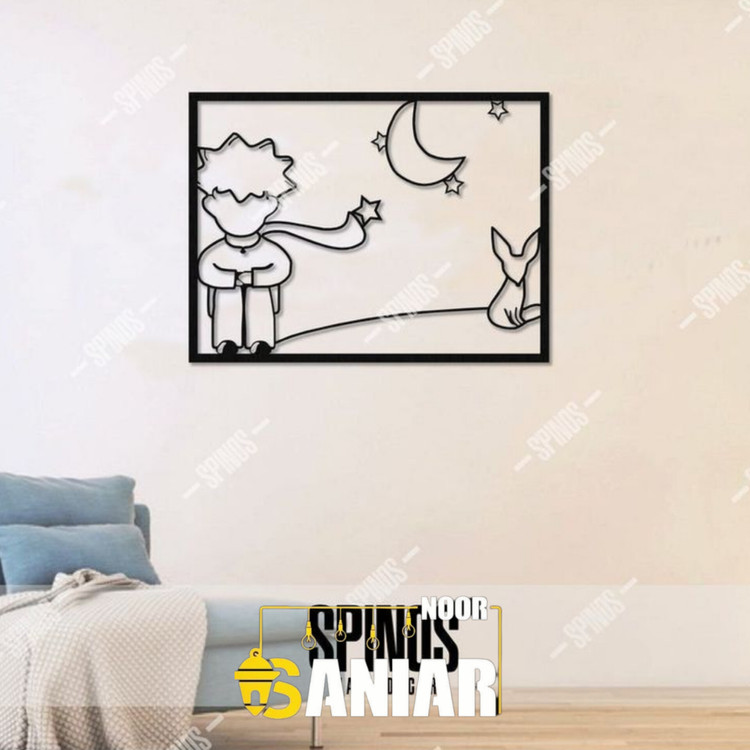 یک تابلو فلزی مشکی مستطیلی با طرح خطی شازده کوچولو و روباه در کنار ماه و ستارهها، نصب شده روی دیوار سفید اتاق خواب بالای تخت».