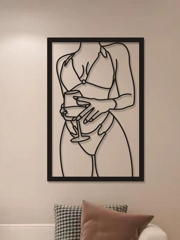 یک تابلو فلزی مشکی مستطیلی با طرح خطی بدن یک زن که جام نوشیدنی در دست دارد، روی دیوار کرمرنگ نصب شده است.»